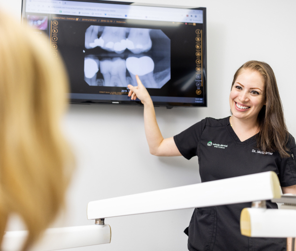 dentist showing a patient their x rays on a screen